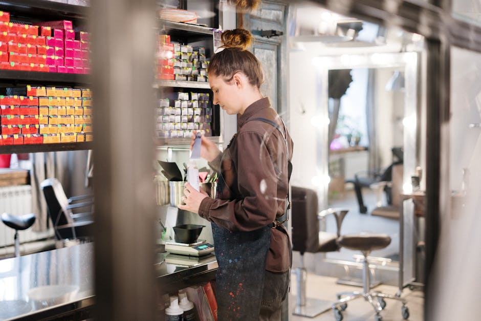 Hairdresser mixing hair color in a modern salon setting with colorful dye boxes